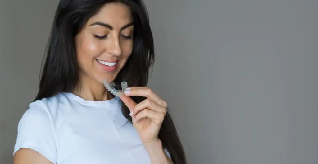 Woman using teeth whitening strip at home