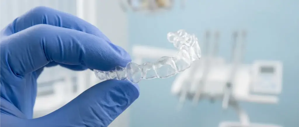 Happy female patient in dental chair after treatment